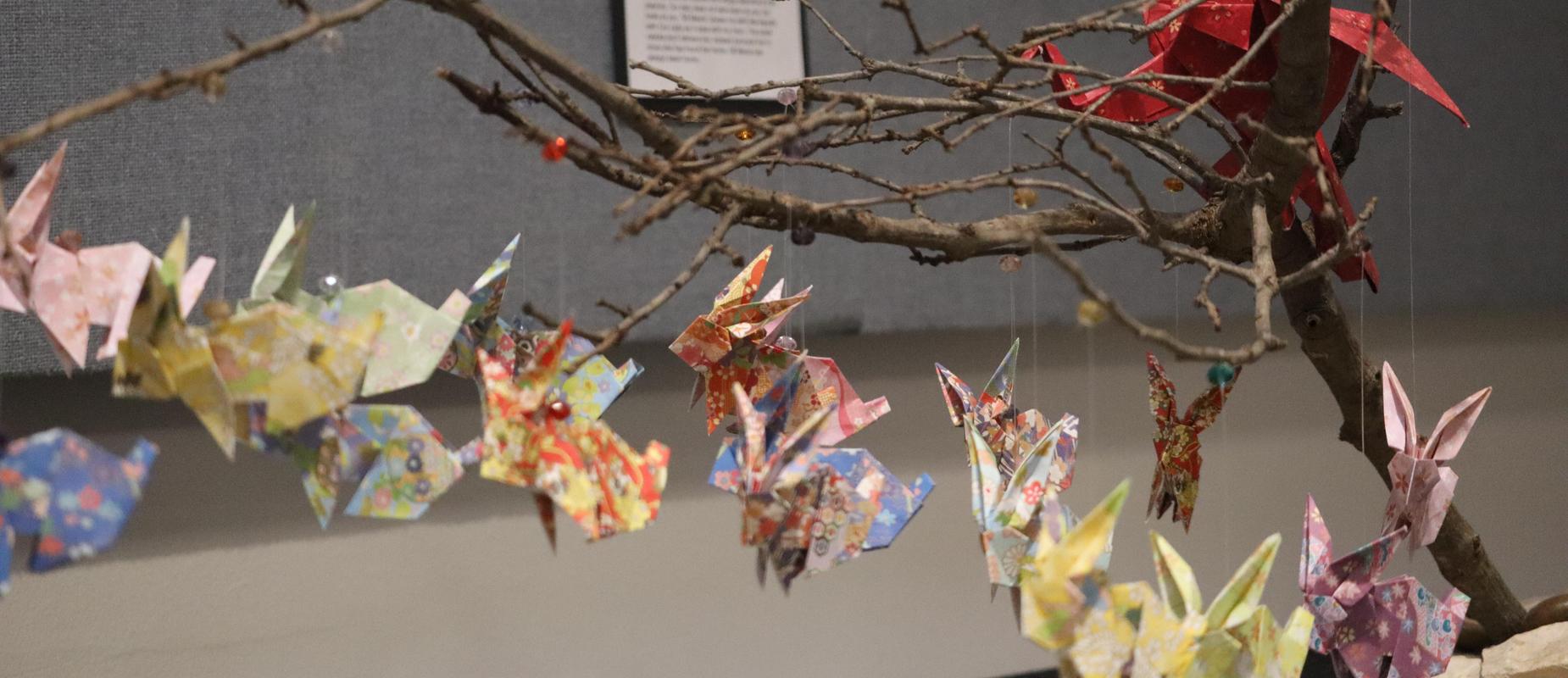 Art installation for DP Exhibit featuring a branch and rabbit origami pieces hanging down like butterflies