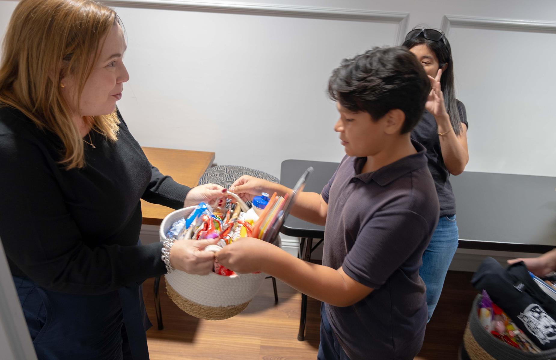 Student gives basket of gifts to board member