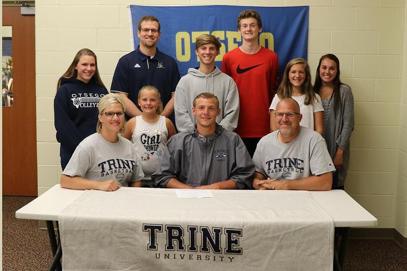 Zak Lucas, surrounded by family, his coach and friends before signing with Trine.