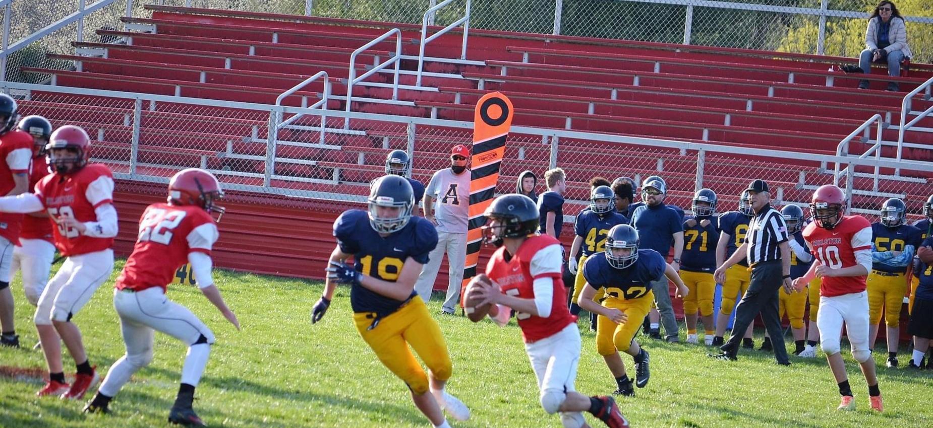 Football players play football on a field.