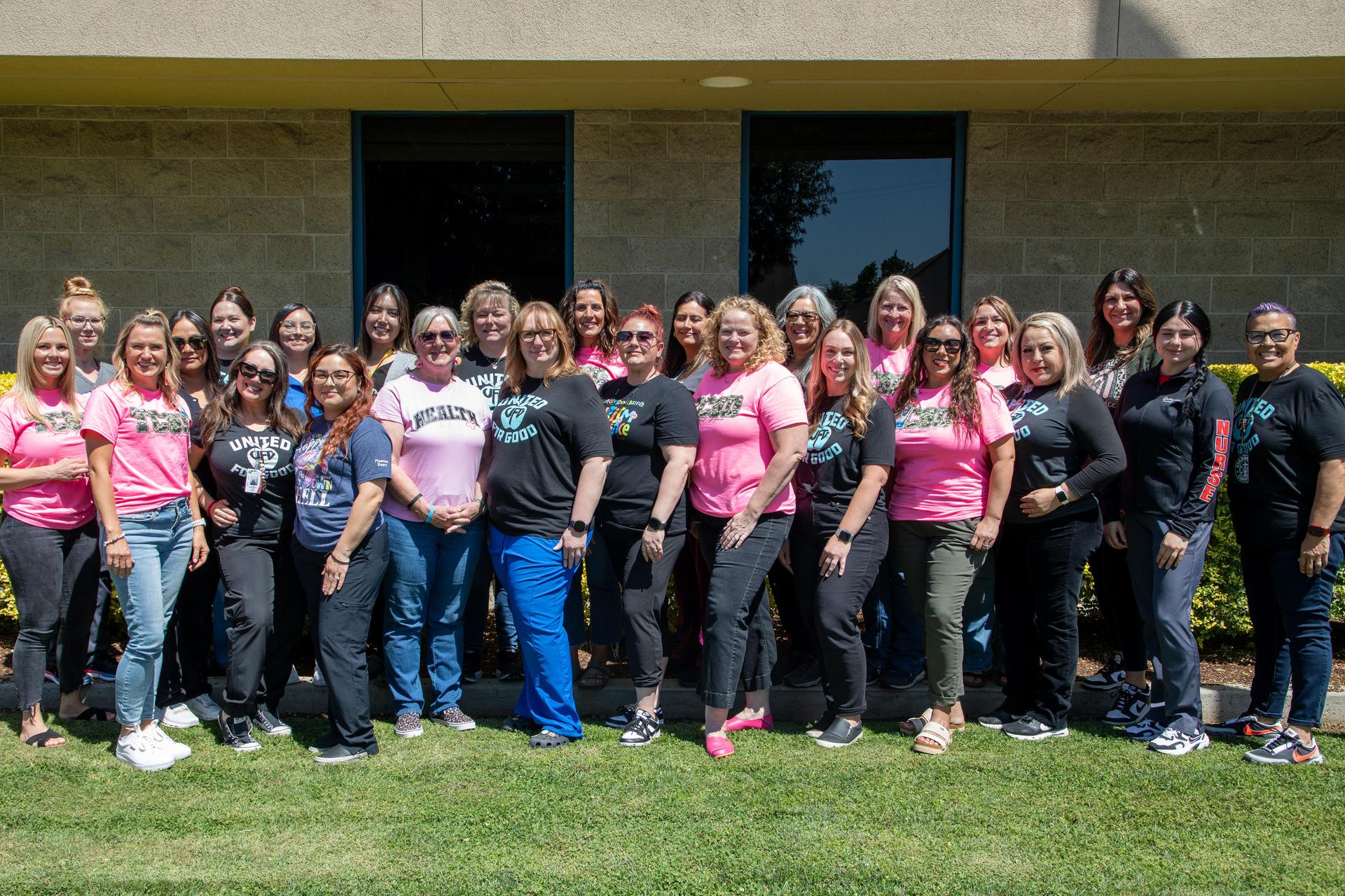 Large group of TCSD nursing staff wearing pink and black shirts outside of the district office building.
