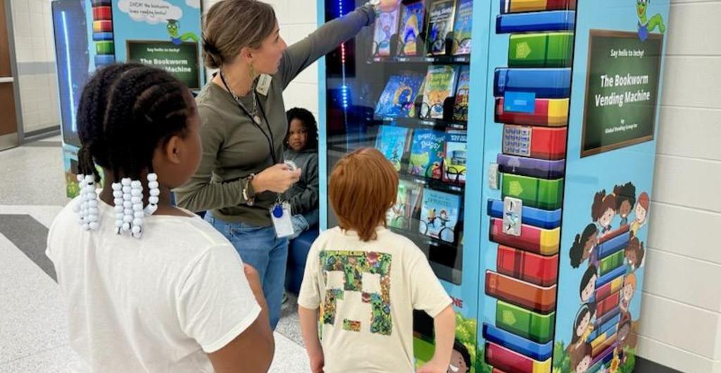 Students choosing books from book machine.