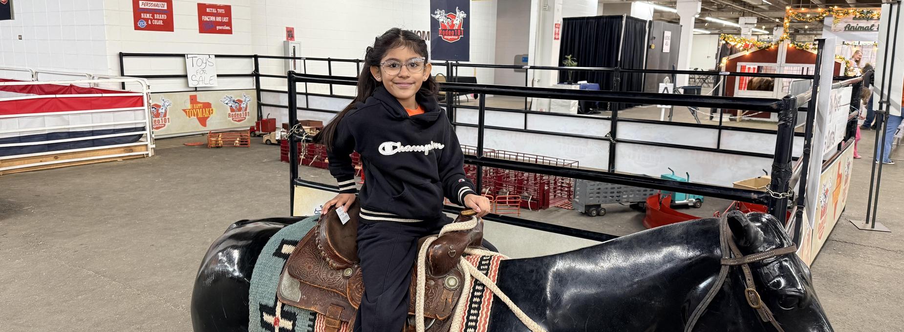 Child riding a toy horse the stock show