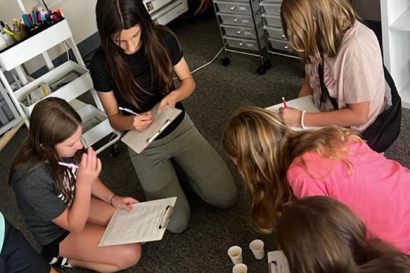 Trafford Middle School students Fiona Wassel, Lily Hunter, Claire Korekach, Lucia Campana, and Layla Carter observe and collect data from the M&M experiment