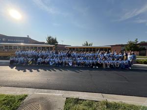 new staff lined up in front of a school bus