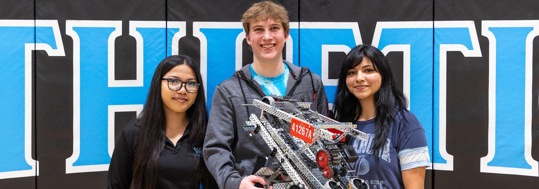 Members of the high school robotics team with their bot