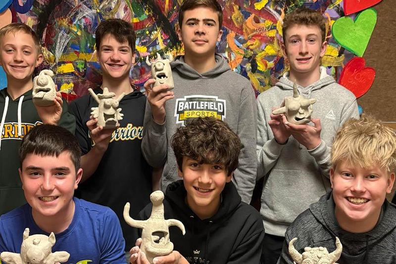 photo of students holding their clay vessels