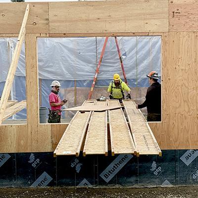 Crew members build up walls for new addition