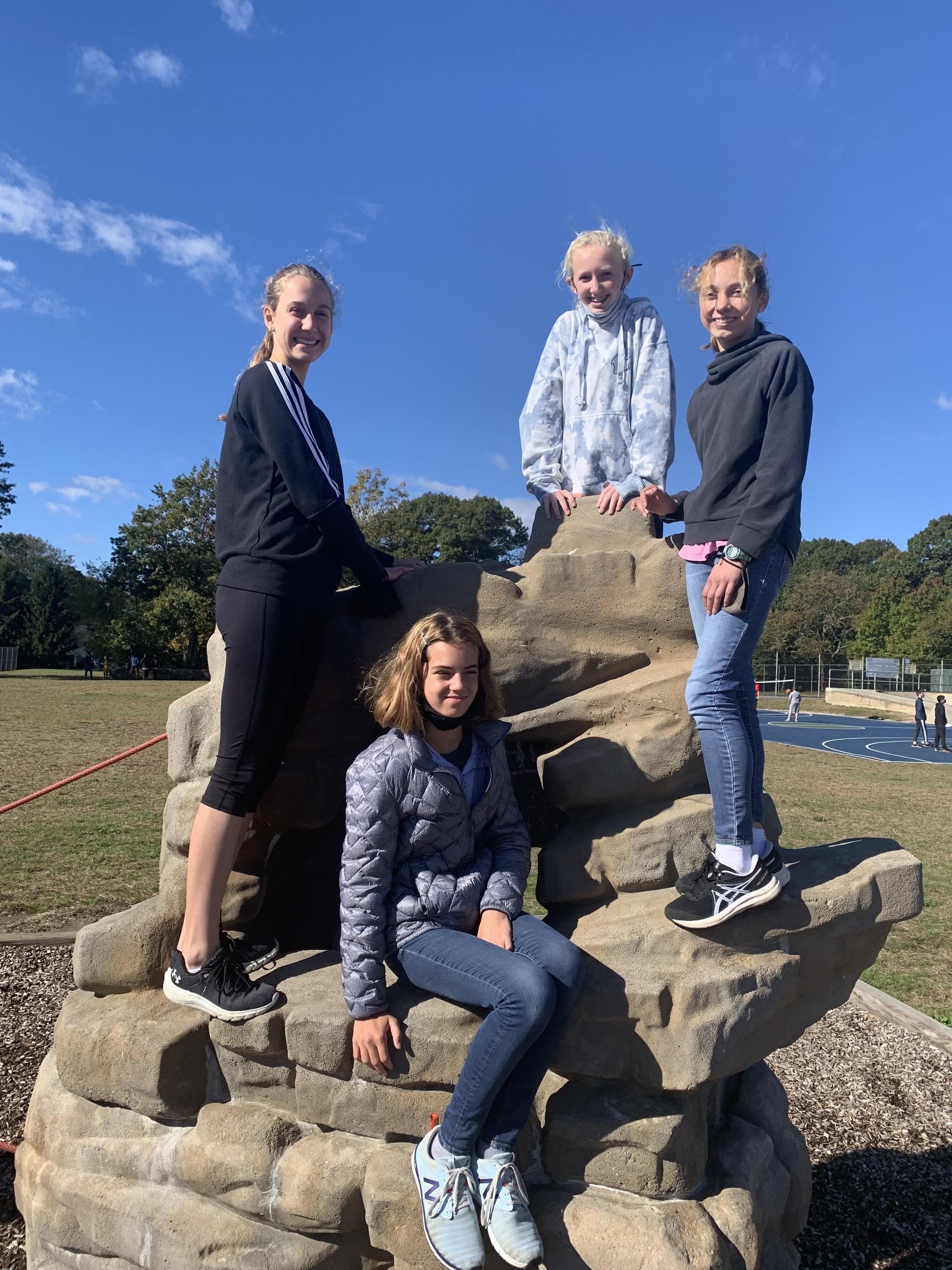 Lawn students on the climbing rocks at recess