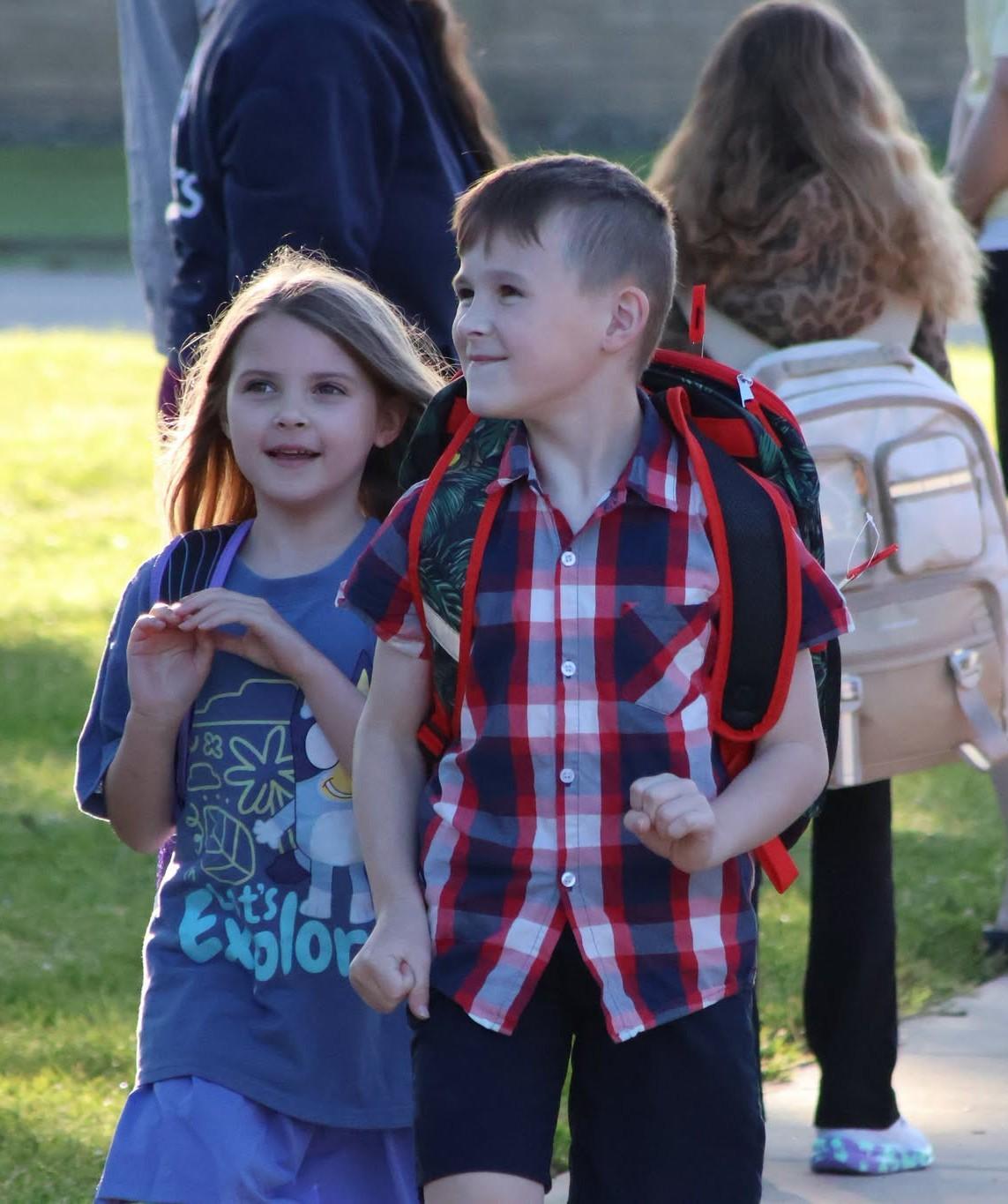 two students walking off the bus
