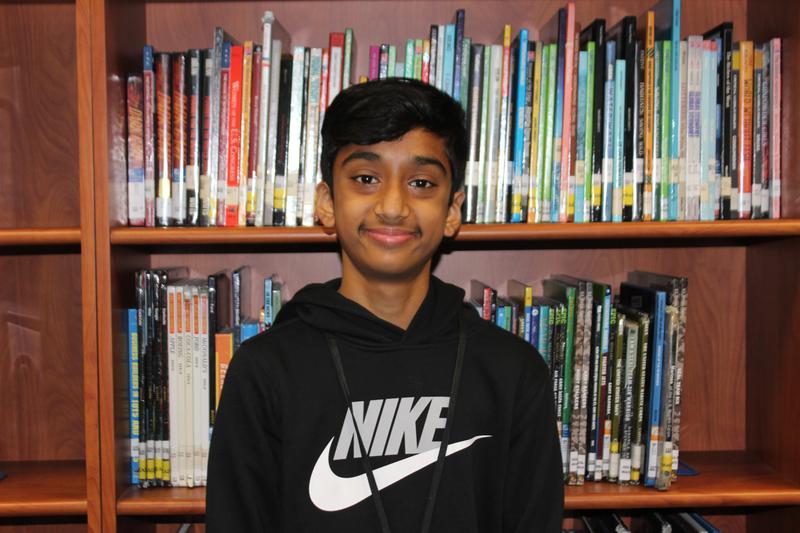 Student standing in front of book case