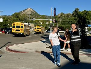 Man directing traffic with bus in background