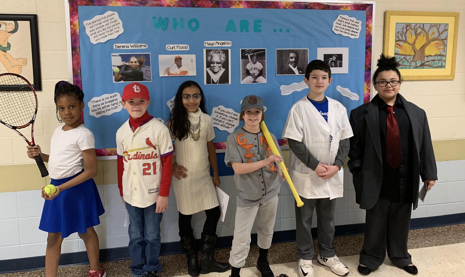 6 students pretending to be wax figures portraying famous Americans: Serena Williams; baseball player Curt Flood; Maya Angelou; Willie Mays; George Washington Carver; and James Brown.