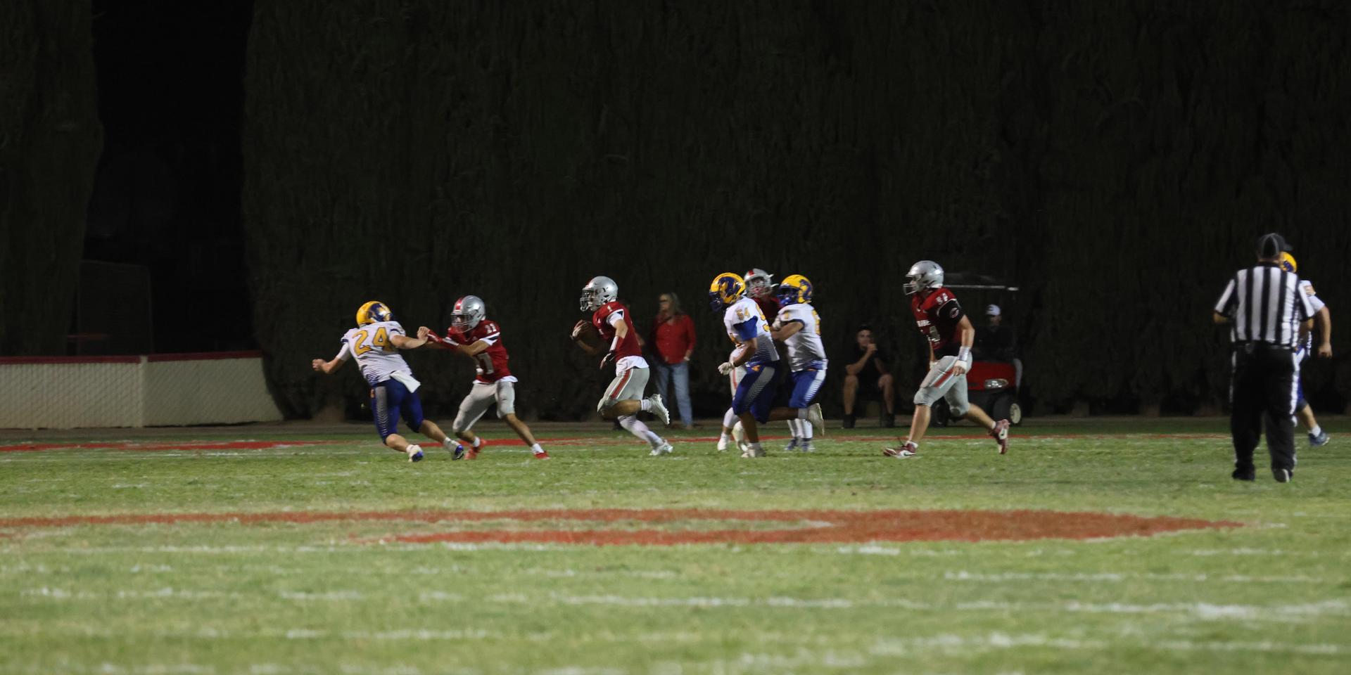 Varsity football players in action against Parlier 42