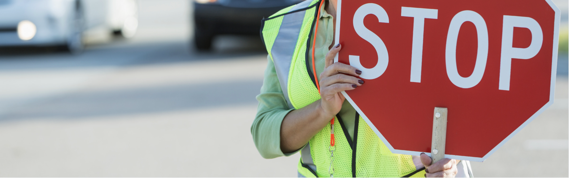 A woman holds up a stop sign