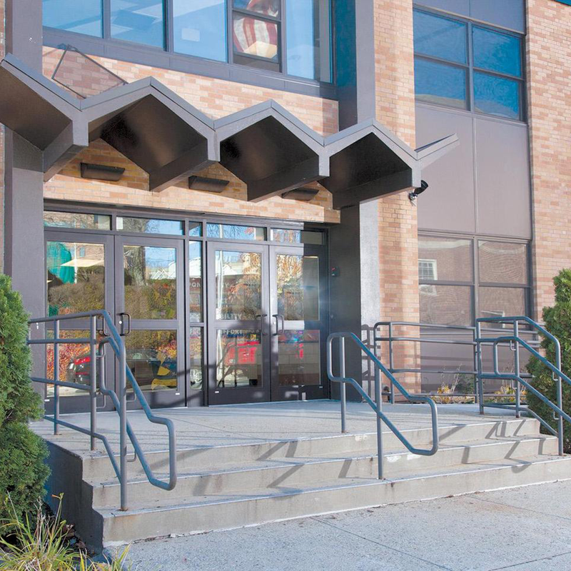Building entrance with a distinctive overhang and accessible stairs.