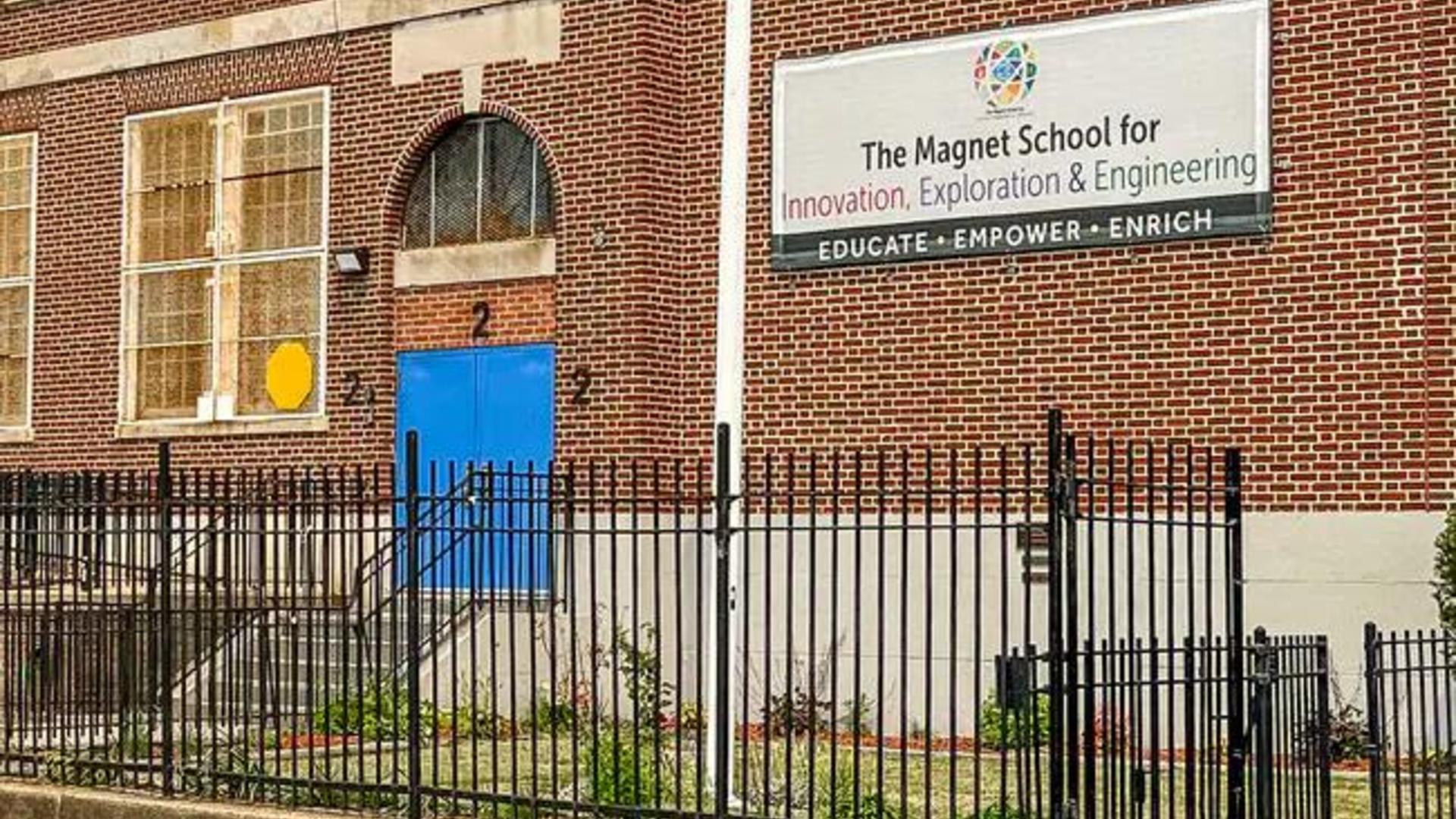 School building with blue door and a large sign promoting innovation and engineering.