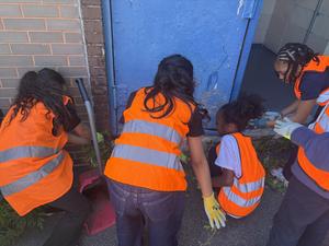 Students working together to pick up weeds