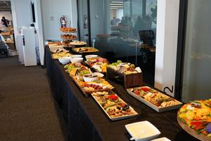 Buffet table filled with assorted dishes, fruits, and desserts.