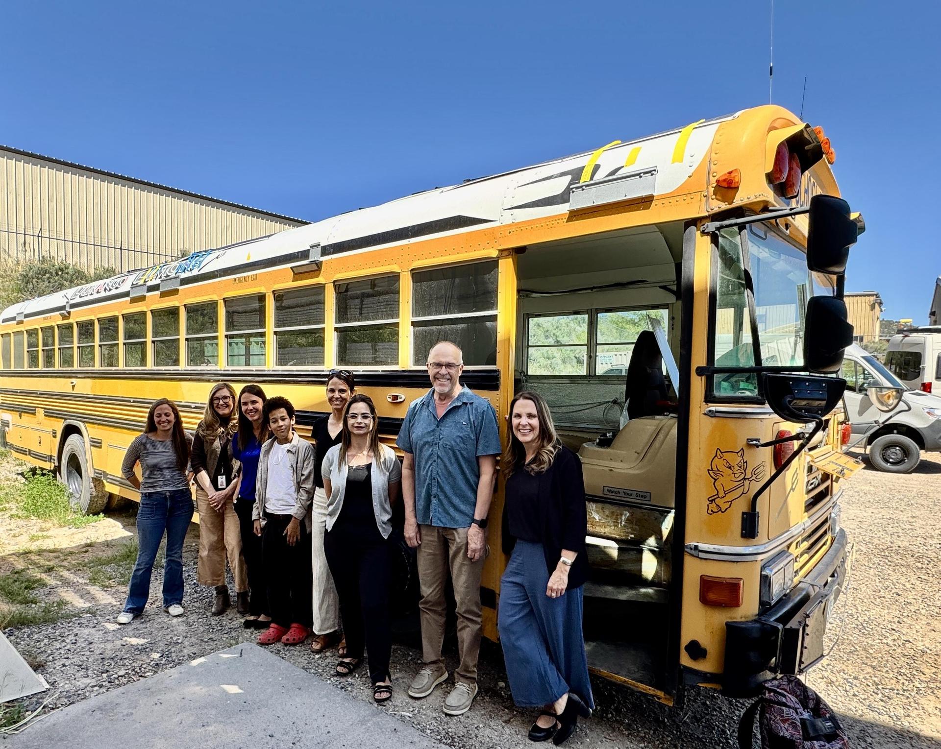 DEF Board standing next to bus