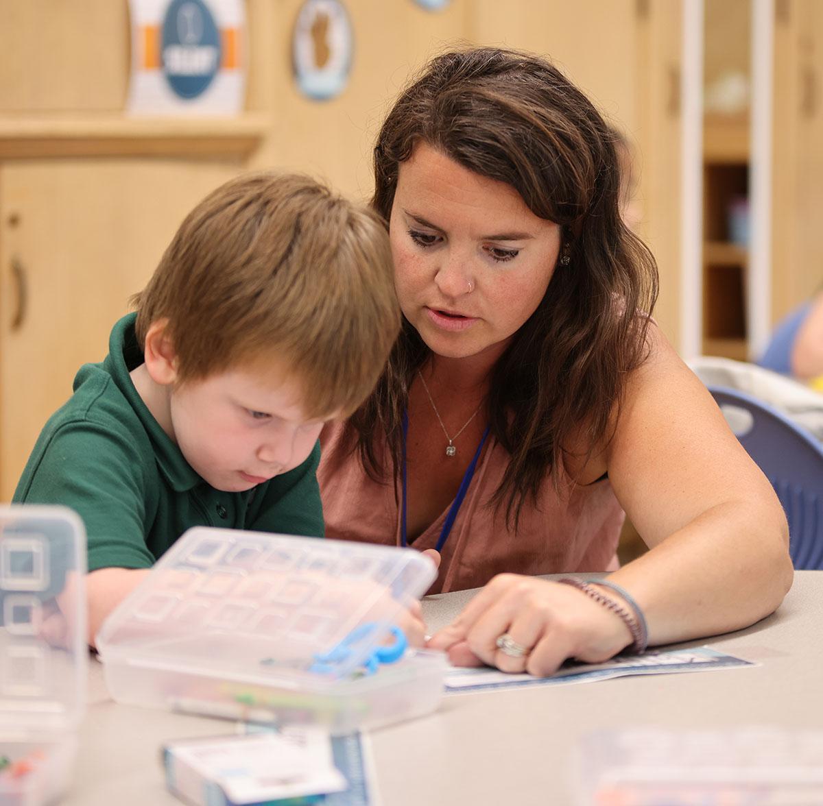 HSA Cedar Rapids Teacher and student interacting at a classroom desk