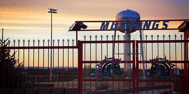 mustang gate with Mountainair water tower at sunset