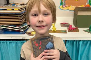 Kindergartener Jaxson Hudock displays his clay lobster in an ocean habitat