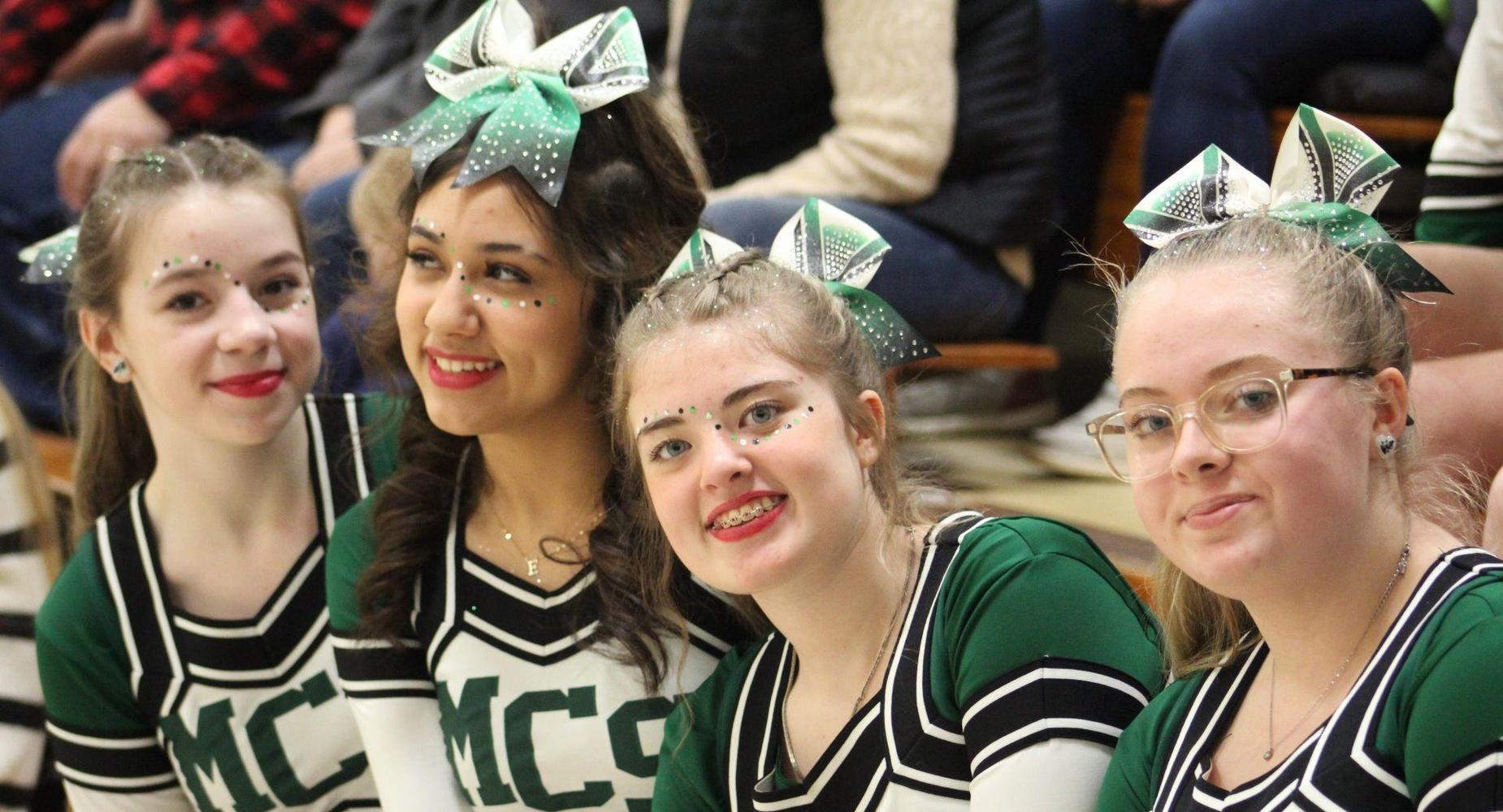 MCS cheerleaders spread school spirit at a basketball game.