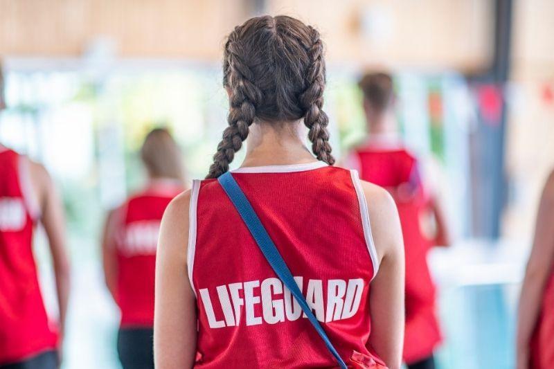 Lifeguards with their backs turned listening to instructions