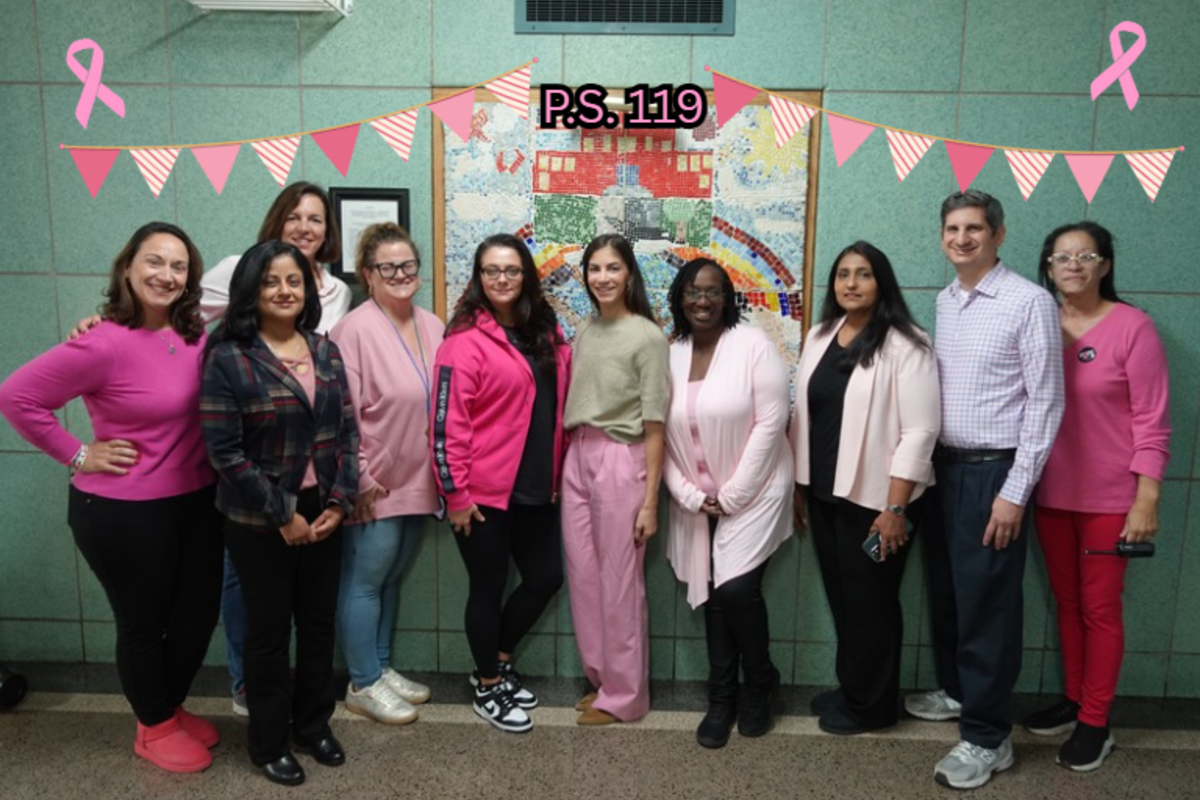 Group of people in pink attire posing in front of a colorful mural, celebrating awareness.