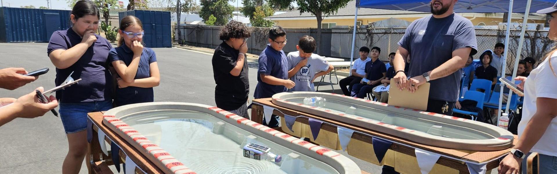 Students participate in a water-based activity with floating objects.