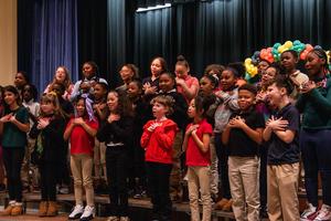 Fourth grade students sing at an assembly