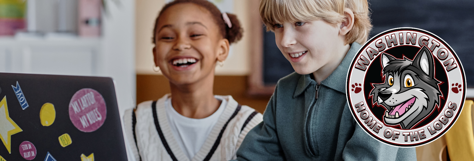 Washington ES shuffle image for homepage - students sitting at a desk smiling