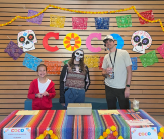 Three people standing at the ticket table for Coco