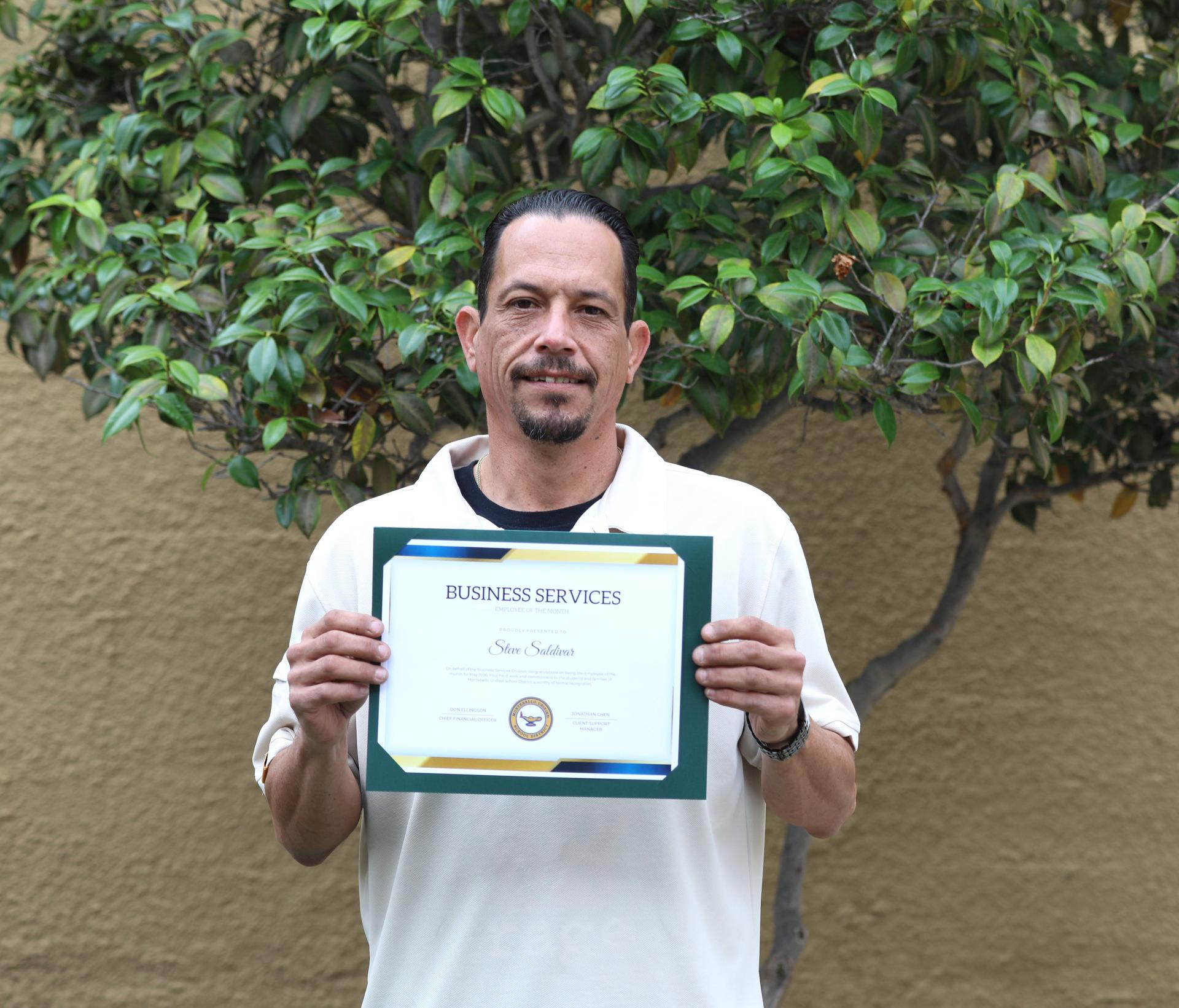 Picture of employee holding certificate 