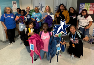 7 middle schoolers, 2 TSD staff, and 4 TDF members holding brand new school supplies