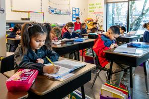 Arco Iris students work on assignments at their desks in their classroom.