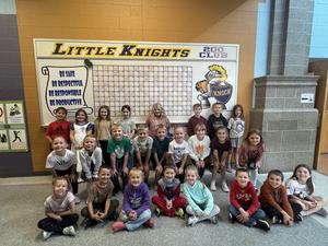 group of primary students in front of little knights board
