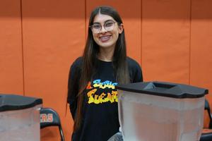 Girl with Puente shirt on in front of two water dispensers
