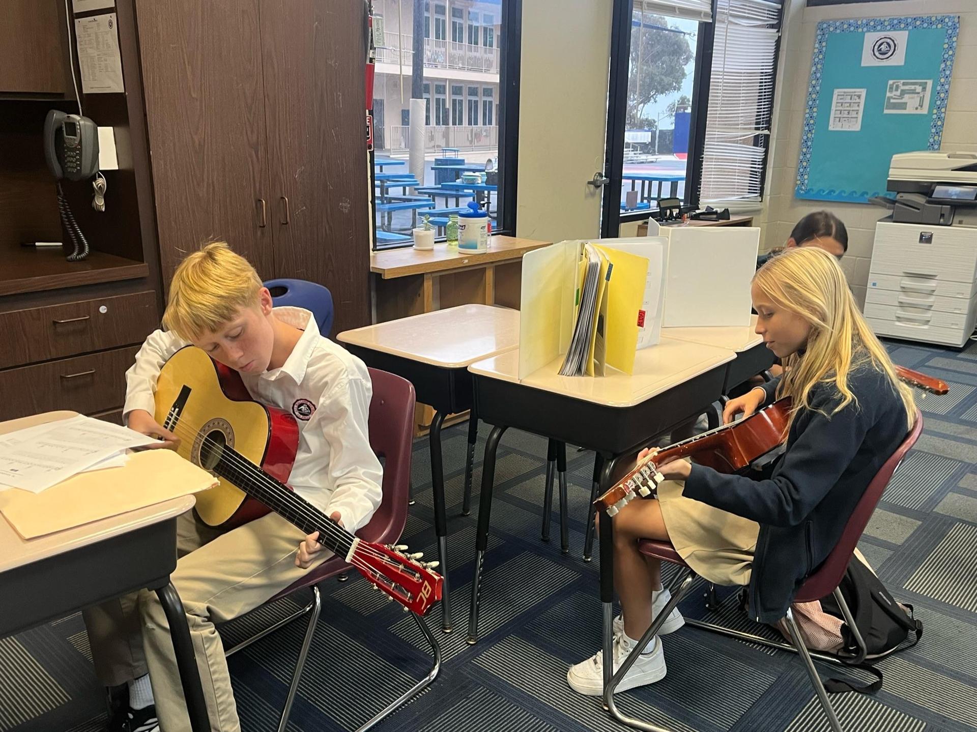 6th and 7th grade student practicing guitar in middle school music elective