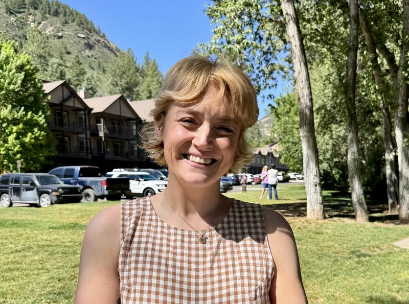 Woman smiles with mountains in background