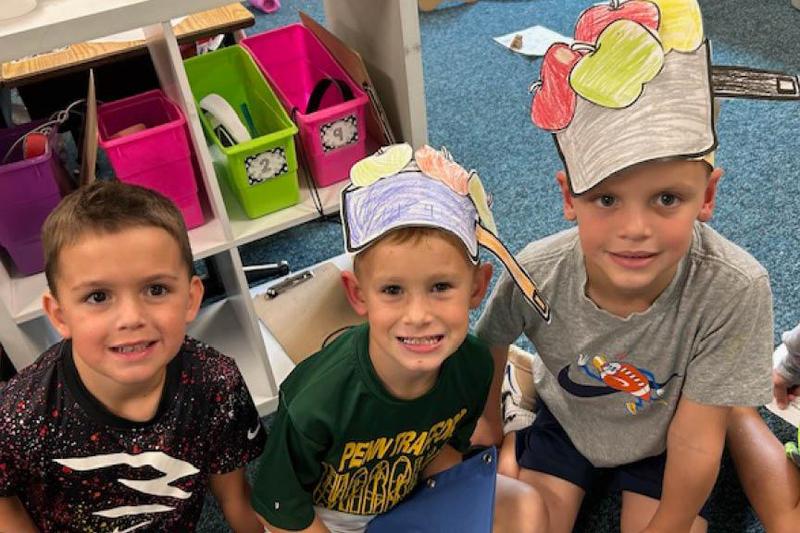 Ashton Fossati, Ryden Rayburg, and Evan Suchy wear apple hats