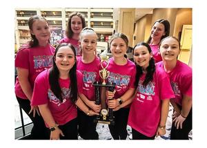 A group of girls wearing bright pink t-shirts