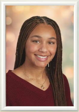 A close up of a student with braids and a maroon sweater