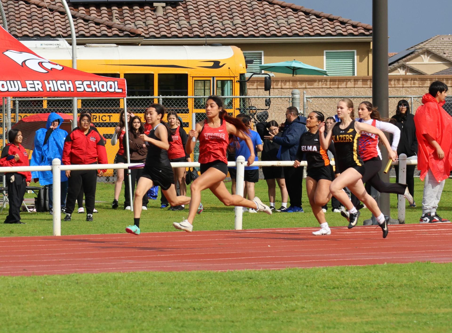 girls running the four by 100 meter relay