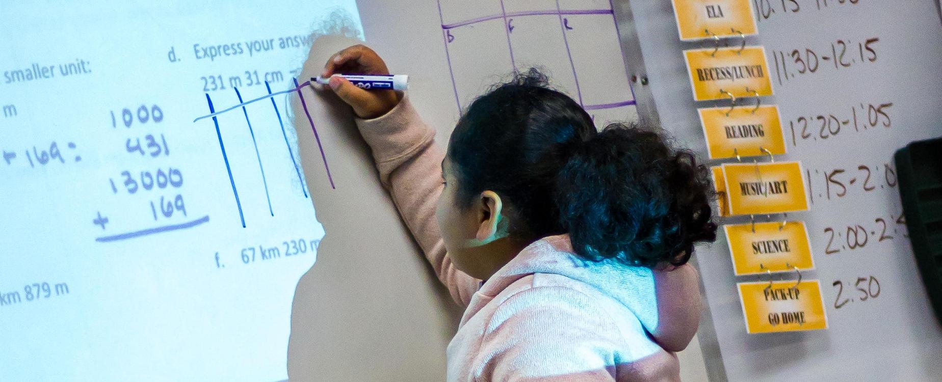 Student writing on white board