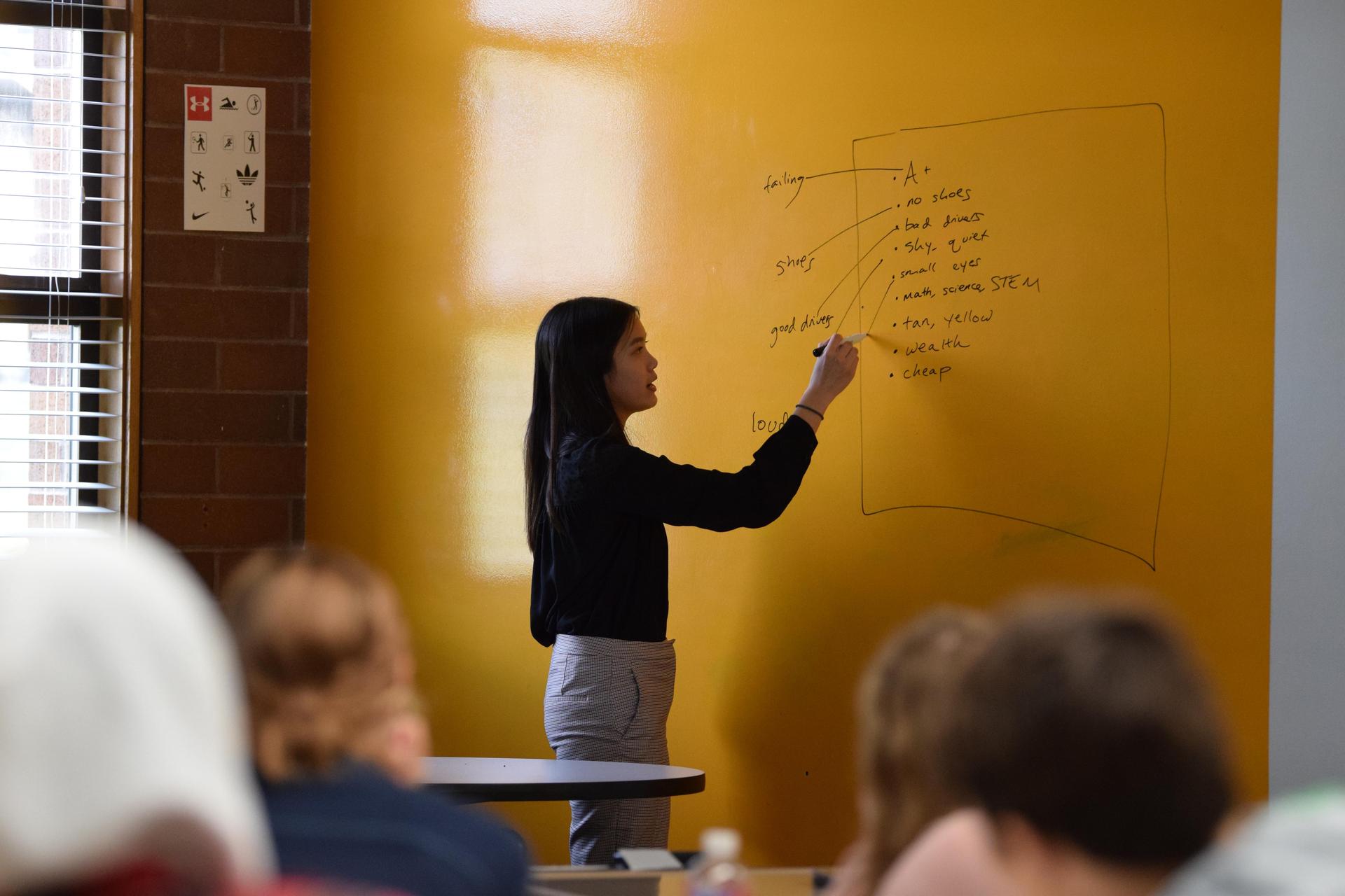 student draws chart on wall during unity day workshop