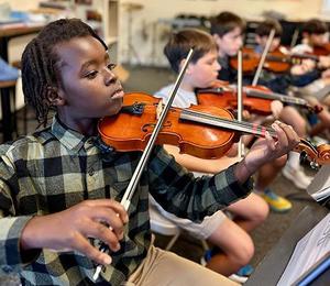 Middle School Orchestra members rehearse for the concert.