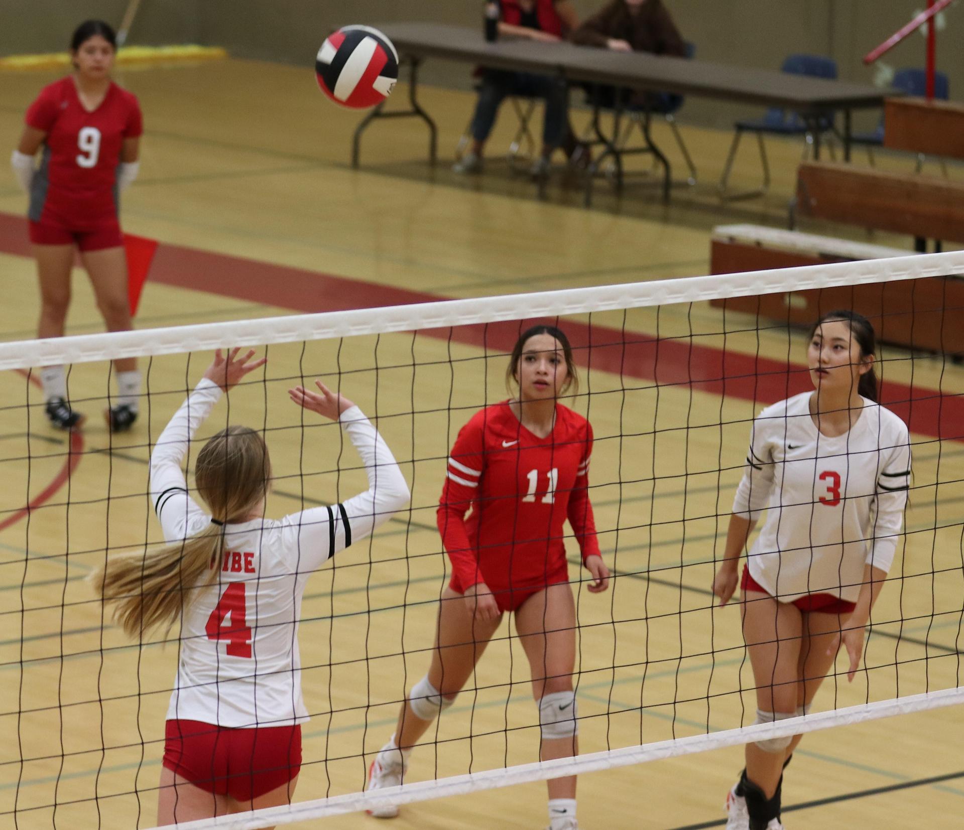 varsity volleyball players in action against Fresno Christian