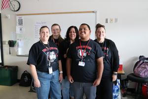 3 students and one teacher wearing black tshirts